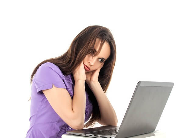 Mujer jóven frustrada viendo una Laptop